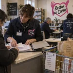 restaurants du coeur brest : bénévole aide une personne à préparer un dossier pour l’aide alimentaire